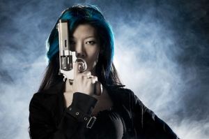 Asian beauty holding gun with smoke
